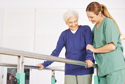 photo of nurse helping elderly woman with physical therapy