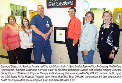 A group of the Stamford Memorial medical staff are standing next to the Diagnostic Services Award for the Joint Commission\&apos;s Gold Seal