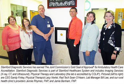 A group of the Stamford Memorial medical staff are standing next to the Diagnostic Services Award for the Joint Commission\'s Gold Seal